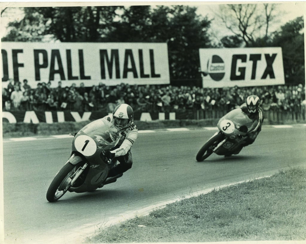 Black and white photo showing Peter Williams putting the pressure on Giacomo Agostini at Brands Hatch